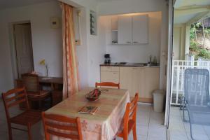 a kitchen and dining room with a table and chairs at Studio cosy au Moule 30 m² avec jardin privé in Le Moule
