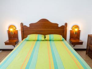 a bed with a wooden headboard and two night stands at Studio chaleureux à Sainte-Anne - 29m² avec jardin. in Sainte-Anne