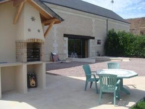 a patio with a table and chairs and a fireplace at Maison charmante en campagne à Mouterre-Silly, Jardin, Terrasse. in Mouterre-Silly