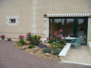 a garden with a bench and flowers in front of a building at Maison charmante en campagne à Mouterre-Silly, Jardin, Terrasse. in Mouterre-Silly