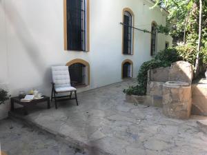 a chair and a table in front of a building at Elegant Villa in El Saucejo with Private Pool in Saucejo