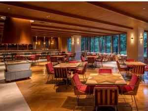 a restaurant with tables and chairs and windows at UNWIND HOTEL & BAR Okunikko in Nikko