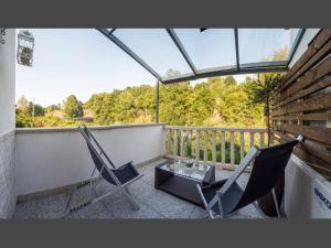 a balcony with two chairs and a glass table at Charming villa in Cividade, 150 m² with private pool in Cividade
