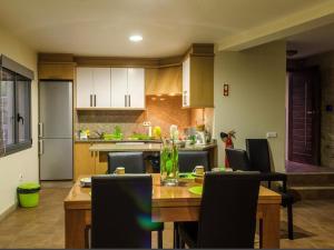 a kitchen with a wooden table with chairs and a dining room at Charming villa in Cividade, 150 m² with private pool in Cividade