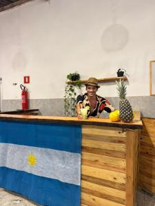 a man in a hat sitting at a counter at La Palma Hostel & Bar in Maragogi