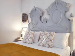 a bed with a large white headboard and pillows at Spacious Apartment in Lisciano Niccone with Mountain View in Mercatale