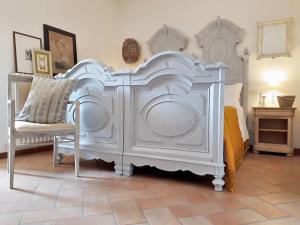 a white bedroom with a large bed and a chair at Spacious Apartment in Lisciano Niccone with Mountain View in Mercatale +27 photos