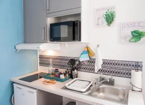 a kitchen counter top with a sink and a sink at Studio accueillant à Baie Mahault - 20 m² avec piscine privée in Baie-Mahault