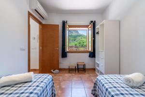 a bedroom with two beds and a window at Finca Ca`n Jaumí, un paraíso con vista al mar y a la montaña in Artá +63 photos