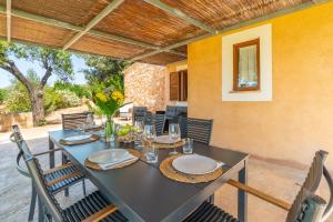 a dining table and chairs on a patio at Finca Ca`n Jaumí, un paraíso con vista al mar y a la montaña in Artá