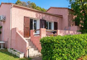 a pink house with stairs leading to a door at Maison charmante à San-Nicolao avec piscine partagée in San-Nicolao