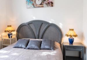 a bed with two pillows on it next to two lamps at Maison charmante à San-Nicolao avec piscine partagée in San-Nicolao