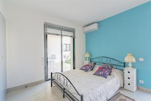 a bedroom with a bed with a blue wall at Appartement charmant, Malaucène, 52 m², piscine partagée in Malaucène