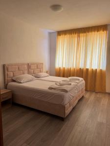 a bedroom with a large bed with a window at Dream Bay Apartments in Tsarevo