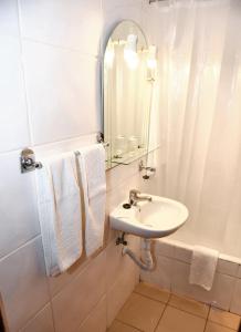 a white bathroom with a sink and a mirror at Charming studio in Funchal, 30m², city view in Funchal