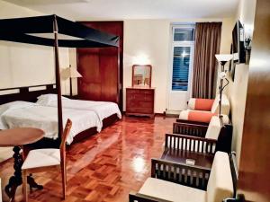 a bedroom with a canopy bed and a chair at Charming studio in Funchal, 30m², city view in Funchal