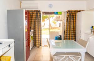 a kitchen with a glass table in a kitchen at Charmant studio avec vue sur mer au Moule, 20 m² + terrasse in Le Moule
