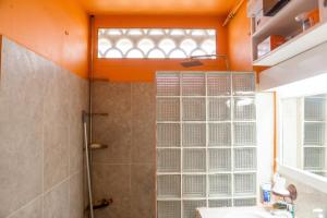 an orange bathroom with a shower and a sink at Charmant studio avec vue sur mer au Moule, 20 m² + terrasse in Le Moule +10 photos