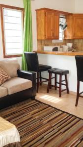 a living room with a couch and a kitchen at Charming Apartment in La Savane, 65 sqm with Terrace in Happy Bay
