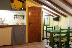 a kitchen with a wooden door and a table at Comfortable Apartment in Robledillo de Gata with Balcony and View in Robledillo de Gata