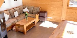 a living room with a couch and a table at Chalet accueillant avec vue sur la montagne - 180 m² - Valmorel in Les Avanchers