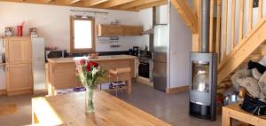 a kitchen with a vase of flowers on a wooden table at Chalet accueillant avec vue sur la montagne - 180 m² - Valmorel in Les Avanchers
