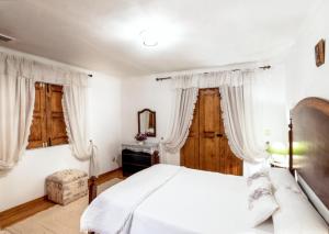 a bedroom with a white bed and two windows at Charming Villa with Private Pool in Lamego in Lamego