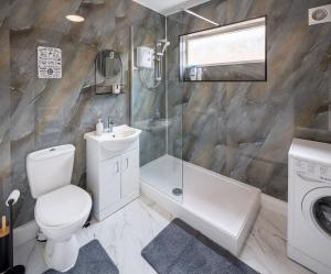 a bathroom with a toilet sink and a shower at Spacious 2BR APT - Sleeps 5 - Private Parking in Highbridge +23 photos
