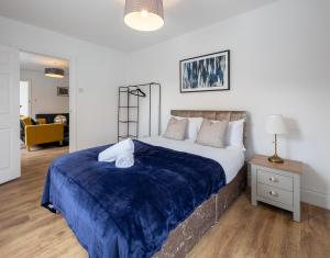 a bedroom with a large bed with a blue blanket at Spacious 2BR APT - Sleeps 5 - Private Parking in Highbridge