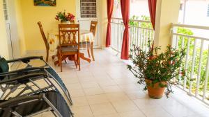 a dining room with a table and chairs and a balcony at Appartement douillet avec vue sur les montagnes au Vauclin in Le Vauclin