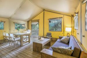 a living room with a couch and a table at Glamping - Quinta do Cascalhal in Arco de Baúlhe