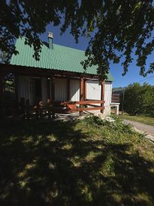 a house with a green roof and a picnic table at Cottage in nature Bare, Savnik in Šavnik