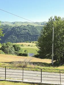 a fence on a field with mountains in the background at Cottage in nature Bare, Savnik in Šavnik