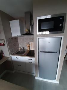 a small kitchen with a refrigerator and a microwave at Appartement charmant à Bandol 30 m² avec vue sur la mer. in Bandol