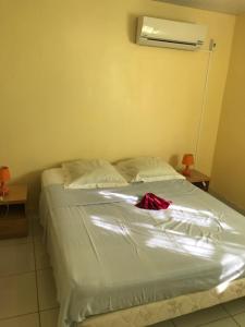 a bed with a red dress sitting on top of it at Appartement avec vue sur la mer à Le Marin, Climatisé, 80 m² in Le Marin