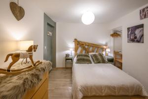 a bedroom with a bed with a wooden horse on a dresser at Appartement spacieux à Orcières – Vue sur la montagne. in Orcières