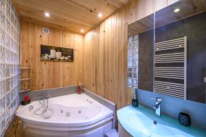 a bathroom with a white tub and a sink at Appartement spacieux à Orcières – Vue sur la montagne. in Orcières