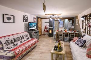 a living room with a couch and a tv and a table at Appartement spacieux à Orcières – Vue sur la montagne. in Orcières +15 photos