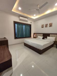a bedroom with a large bed and a window at Hotel Pride in Wardha