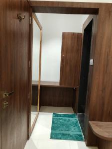 a small room with a door and a green rug at Hotel Pride in Wardha