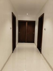 an empty hallway with two doors and a tile floor at Hotel Pride in Wardha +1 photo