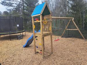 a playground with a wooden playset and a swing at Marieborg Apartments in Ekshärad
