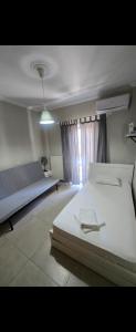 a bedroom with a large white bed and a window at Spacious stay in Preveza