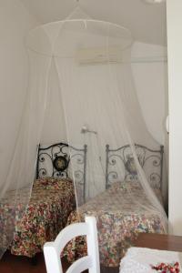 a bedroom with two beds with a canopy at Agriturismo Abbonbri in Quarrata