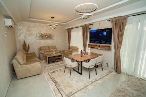 a living room with a table and chairs and a television at Amon Private Pool Residence in Podgorica