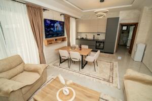 a living room with a table and chairs and a kitchen at Amon Private Pool Residence in Podgorica