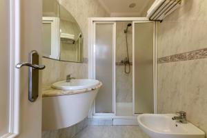 a bathroom with a sink and a mirror and a tub at Hostal Costa Coruña in A Coruña
