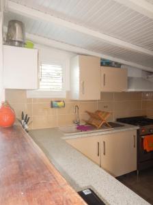 a kitchen with white cabinets and a sink at Chalet confortable au Vauclin avec piscine privée in Le Vauclin