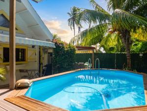 a swimming pool in the backyard of a house at Chalet confortable au Vauclin avec piscine privée in Le Vauclin
