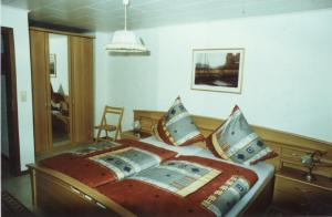 ein Schlafzimmer mit einem Bett und einem Stuhl darin in der Unterkunft Ferienwohnung Steinebach in Daun